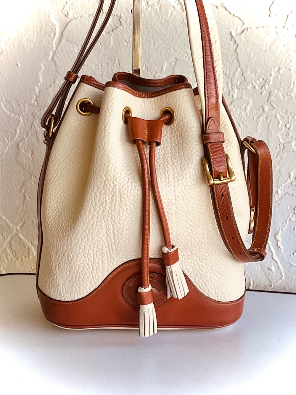 VINTAGE DOONEY AND BOURKE CREAM AND TAN LEATHER SHOULDER BUCKET